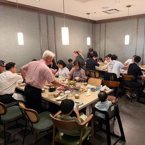 Diners of all ages enjoy a lively meal together at a Korean BBQ restaurant.